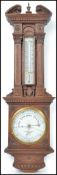 An early 20th century Negretti and Zambra oak aneroid barometer having carved classical columns with