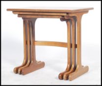 A vintage retro 20th century G-Plan nest of tables having square tops with played legs united by