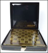 A Manopoulos classical style chess set with gilt metal and silvered metal pieces, with chess board