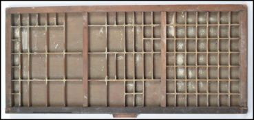 A vintage 20th century wooden and brass printers block tray having varying sized sections.