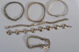 A good collection of vintage sterling silver bangles and bracelets to include a heart and flower