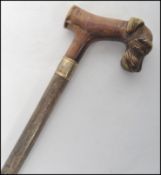 A 20th century gentleman's walking stick cane having a tapering wooden shaft with silver white metal