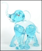 An unusual 20th century / 1960's retro glass elephant figurine. Blue glass with colourful eyes and