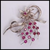 A white gold and ruby floral spray brooch with ins