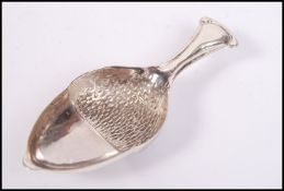 A sterling silver caddy spoon in the form of an ac