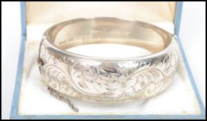 A silver hallmarked ladies rococo chased bangle wi