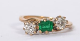 A 9ct gold three stone diamond and emerald ring ha