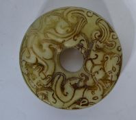 An Oriental jade carved bi of roundel form with ho