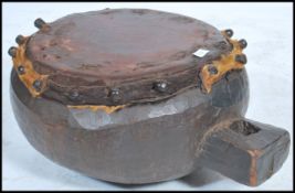 A 20th century African carved large hardwood tribal drum having a carved recess for hanging and