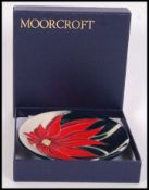 A Moorcroft ceramic tube lined pin dish coaster decorated in the Scarlet pattern with impressed