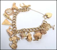 A hallmarked 9ct gold charm bracelet having a heart padlock clasp with charms to include bunny,