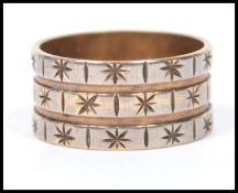 A hallmarked 9ct gold triple band ring having an engraved star pattern. Weighs 4.8 grams.