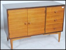 A mid century retro teak wood sideboard dresser being raised on shaped legs comprising cupboards and