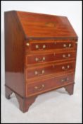 An Edwardian mahogany inlaid bureau desk being raised on bracket feet with a chest of drawers