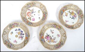 A group of four 19th century ribbon plates having hand painted floral sprays, each plate having a