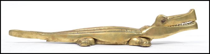 An early 20th century large novelty cast brass nut cracker in the form of a crocodile with opening