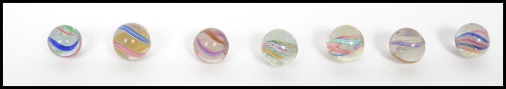 A group of seven 19th century Victorian latticino swirl ribbon air twist marbles having pontil