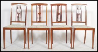 A set of four early 20th century Edwardian dining chairs raised on square tapered legs with pad