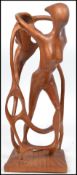 A contemporary carved ethnic hardwood one piece wooden sculpture of human female nude form being