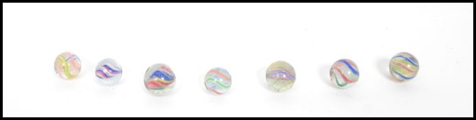A group of seven 19th century Victorian latticino swirl ribbon air twist marbles having pontil