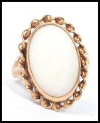 A hallmarked 18ct gold opal ring having a large opal cabochon with rope twist border, weighs 3.8