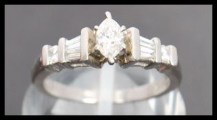A 900 platinum and diamond ring. The ring having a central marquise cut diamond with baguette and