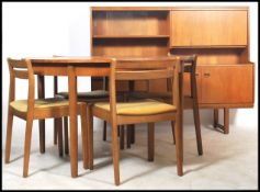 A 1970's retro Danish inspired teak wood dining room suite comprising round extending dining table