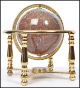 A small desk top 20th century spherical globe having semi precious stone inlay. The globe on