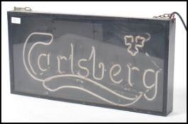 A retro 20th century shop advertising point of sale neon sign for Carlsberg. The neon being housed