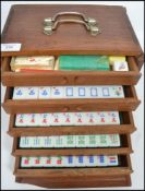 A vintage 20th century Oriental Chinese Mahjong set contained within a drawered wooden cabinet
