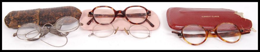 A group of early 20th century reading glasses to include two tortoise shell pairs, a bifocal armless