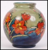 A good 1930's Moorcroft pottery bulbous shaped vase being decorated in the Freesia pattern having