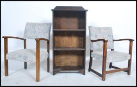 A pair of 1930's beech wood low fireside armchairs having matching upholstery together with an oak