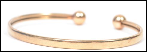 A hallmarked 9ct gold bangle bracelet having ball finial ends. Weighs 5.4 grams. Measures 6.5 cm