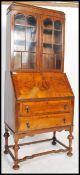 A 1930's good Queen Anne revival walnut bureau bookcase having twin glazed door bookcase cabinet