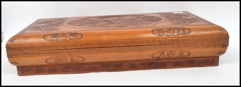 A 20th century Chinese hardwood box carved with scenes of dragons and butterflies. The box with