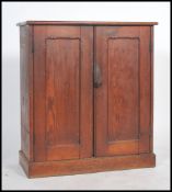 A Victorian pitch pine school cupboard having twin doors with chamfered edge fielded panels inset