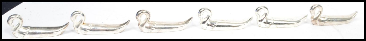 A set of six 20th century silver plated knife rests in the form of swans. Measures 8 cm long.