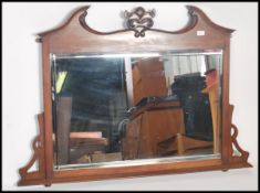A Victorian carved and panelled mahogany over mantel with with broken swan neck pediment above a