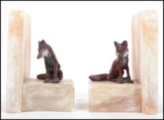 A pair of early 20th century marble / alabaster bookends. Each surmounted with a  seated cold