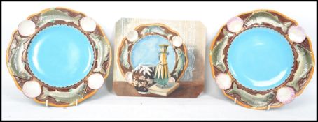 A pair of Victorian Minton Majolica fish plates. The borders moulded with leaping fish between