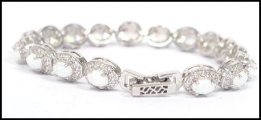 A 20th century ladies silver and opal panelled bracelet interspersed with cz stones having a prong