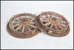 A pair of early 20th century inner rim car / cart wheels, the wheels set with wooden spokes within a