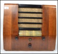 A vintage 20th century Peto Scott walnut cased valve radio. Having a central speaker to the front,