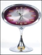 A vintage mid century Coral retro alarm clock of oval form having faceted hands and baton numerals