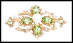 A hallmarked 9ct gold peridot and pearl brooch pin. The brooch being set with  oval and round cut