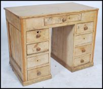 A 19th century pine kneehole desk of small proportions having twin pedestals, each with bank of