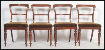 A set of 4 19th century mahogany kidney back - balloon back dining chairs being raised on turned