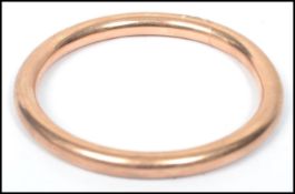 A hallmarked 9ct gold slave bangle of plain form having rubbed hallmarks, tests as 9ct gold.