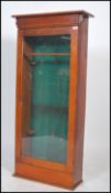 An early 20th century gun cabinet in oak having baize lined sectional interior with full length glas